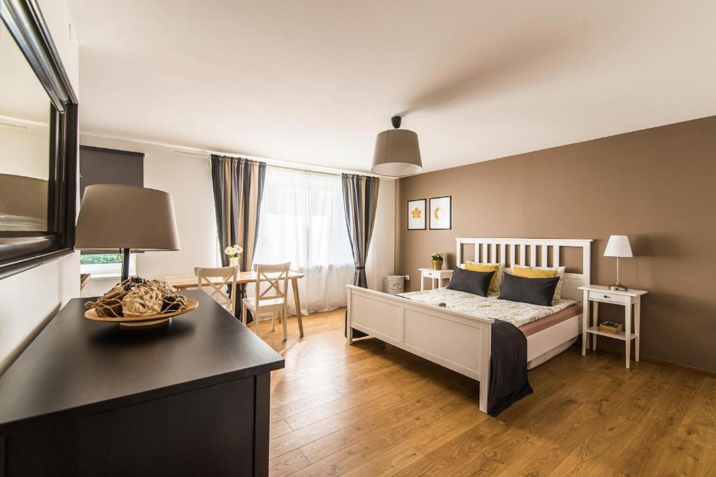 a bedroom with a bed and a living room at Sunshine Apartment in Liepāja