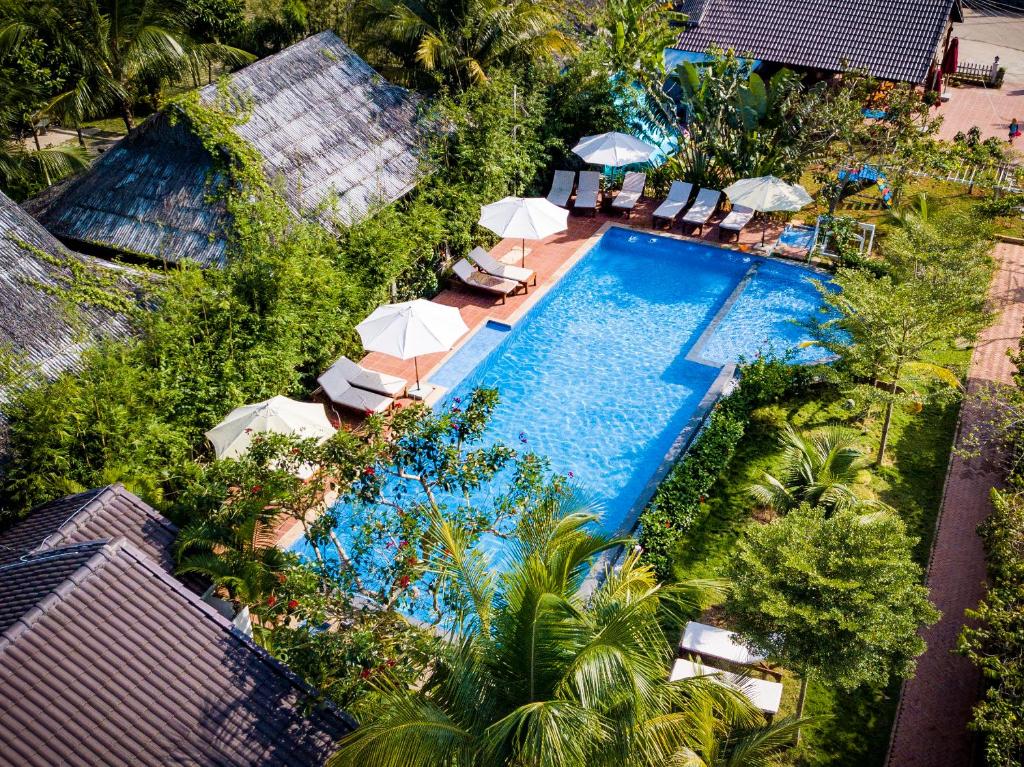 an overhead view of a swimming pool with umbrellas at La Casa Resort in Phú Quốc