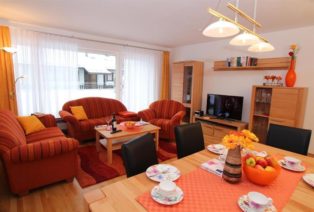 uma sala de estar com mesa e cadeiras e uma sala de estar em Ferienwohnung Keßler em Bad Hindelang