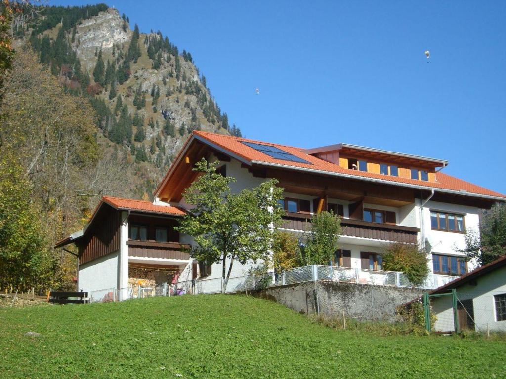 un gran edificio con una montaña en el fondo en Haus Zillach, en Bad Hindelang