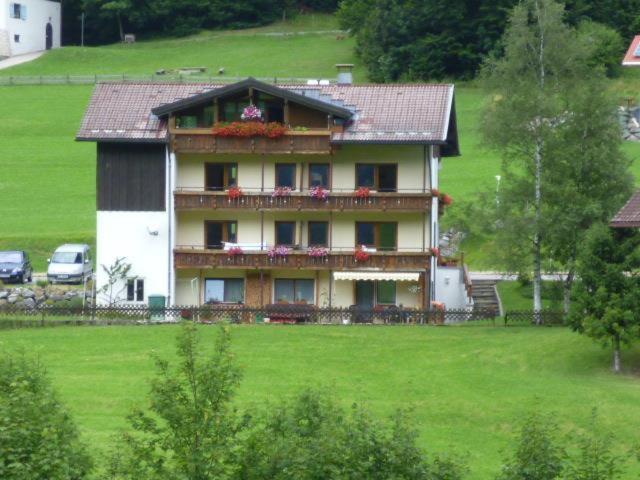 uma casa grande numa colina com um campo verde em Haus Marianne em Oberjoch