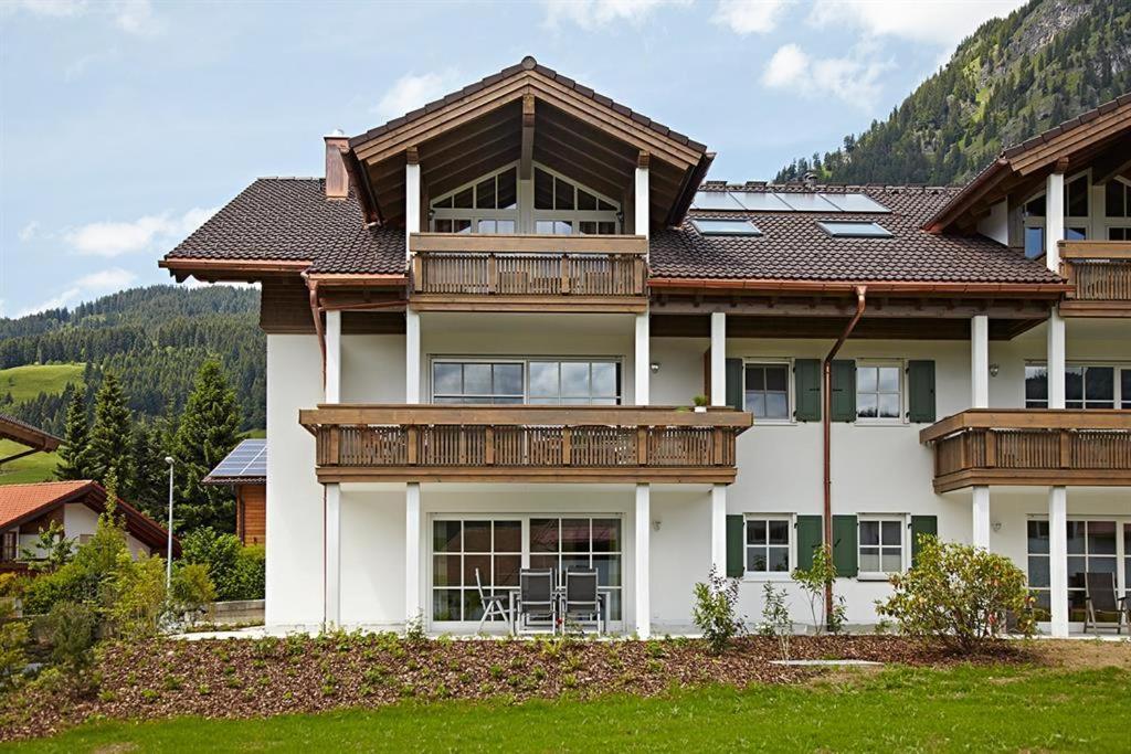 Una casa grande con balcones de madera en la parte superior. en Ferienwohnung "Beim Schofer" en Bad Hindelang