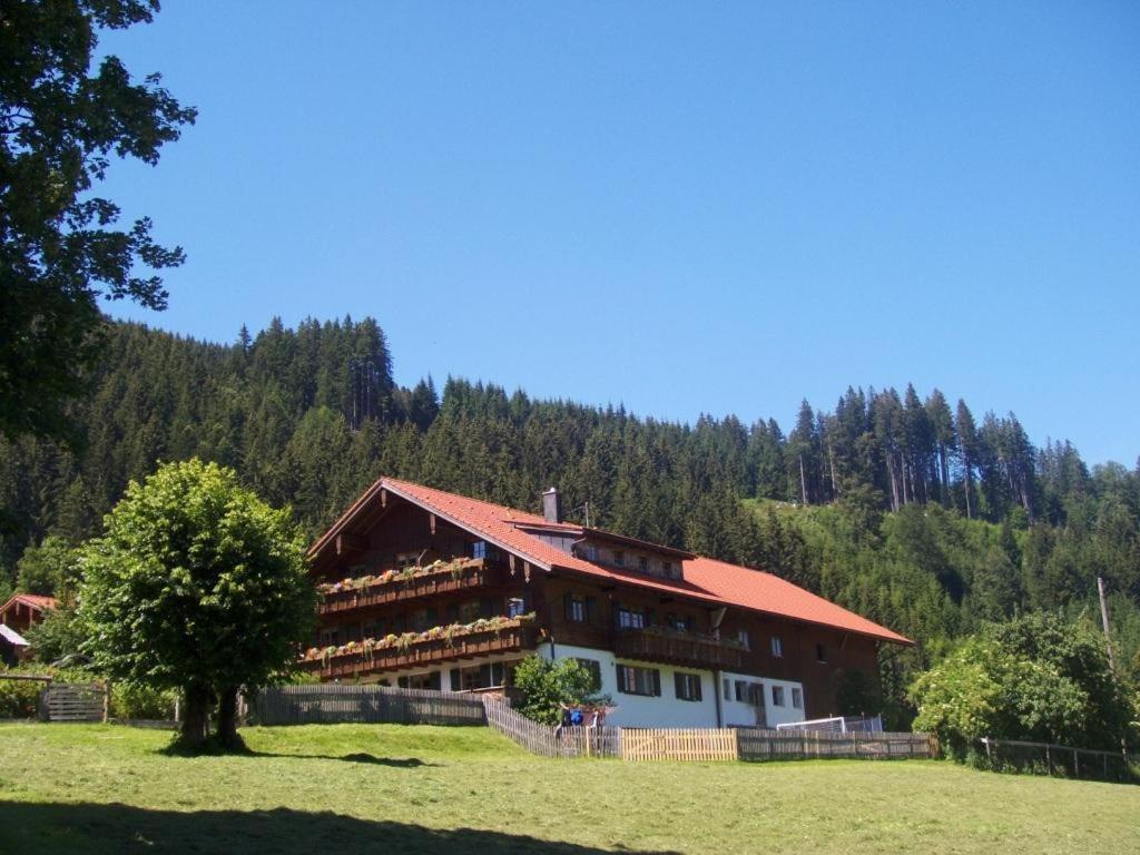 a large building in the middle of a field at Ferienhof Beim Kemptar in Bad Hindelang