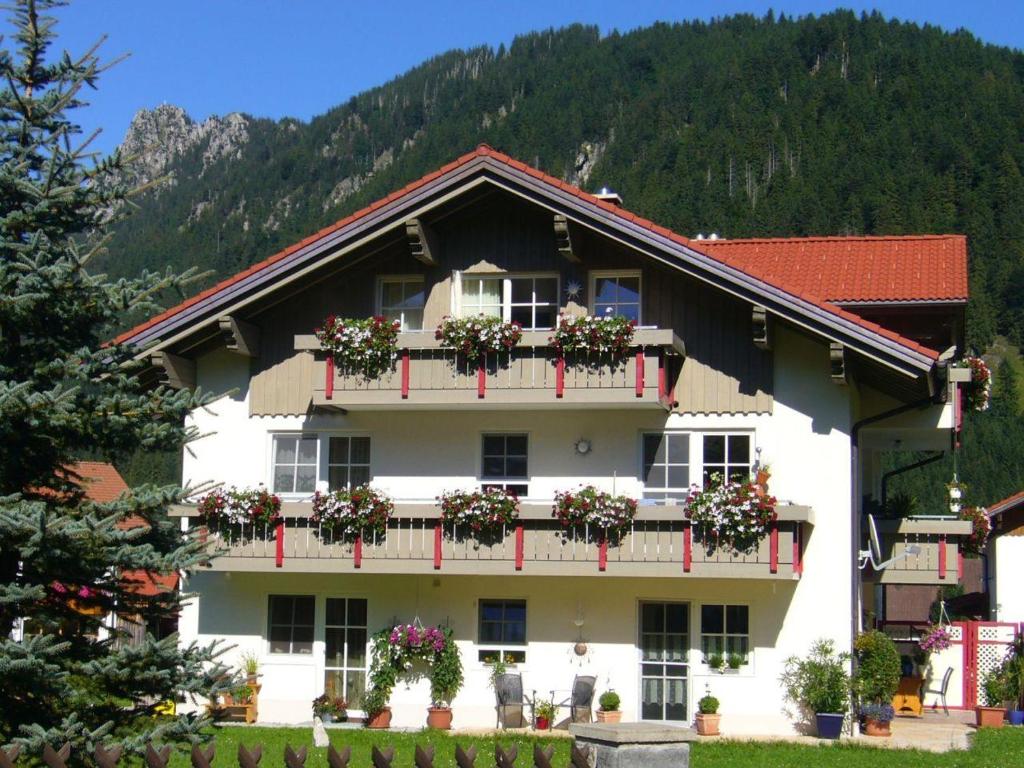 um grande edifício branco com flores nas varandas em Haus Bergkristall em Bad Hindelang