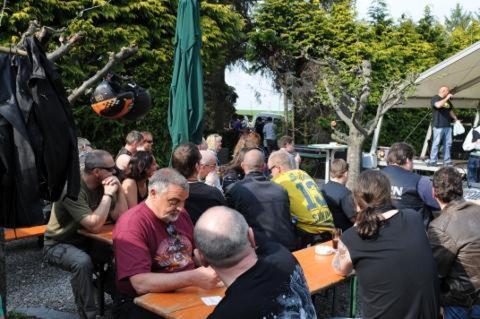 Un groupe de personnes assises à des tables dans une foule dans l'établissement Green Mile Motel, à Nideggen