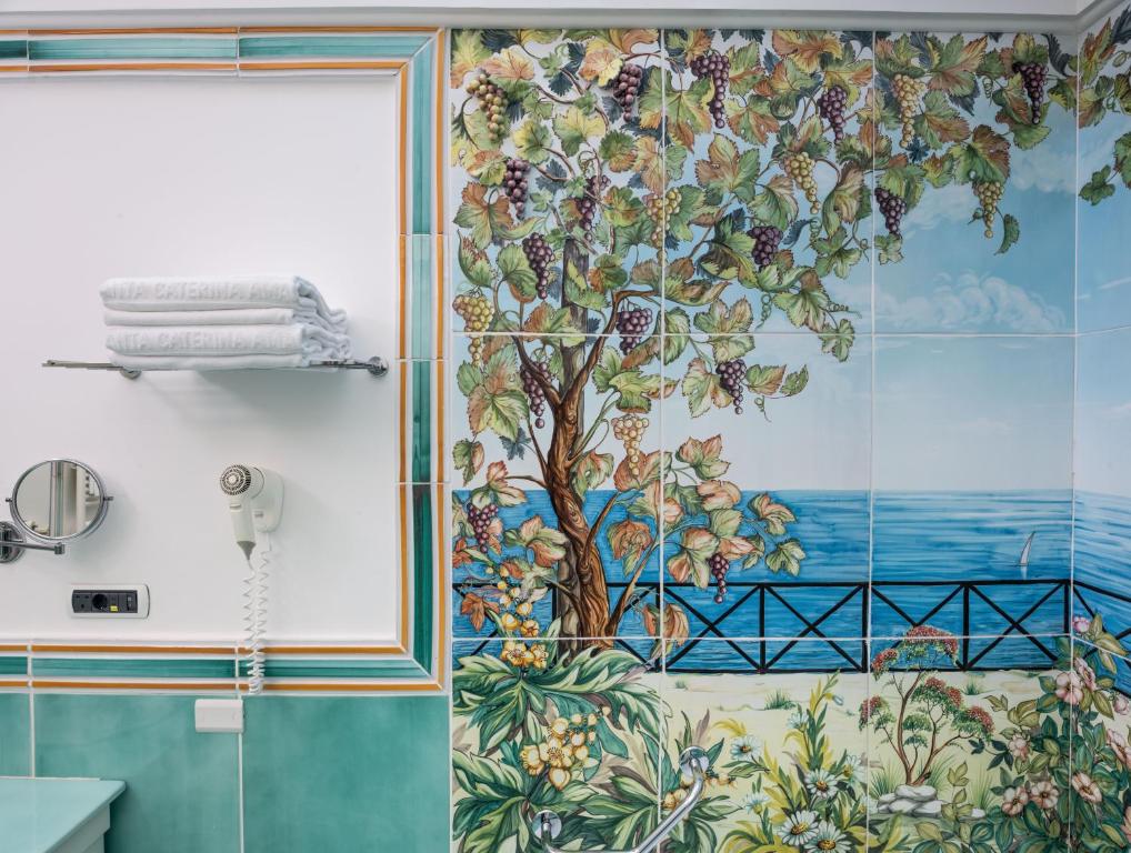 a bathroom with a tree mural on the wall at Hotel Santa Caterina in Amalfi