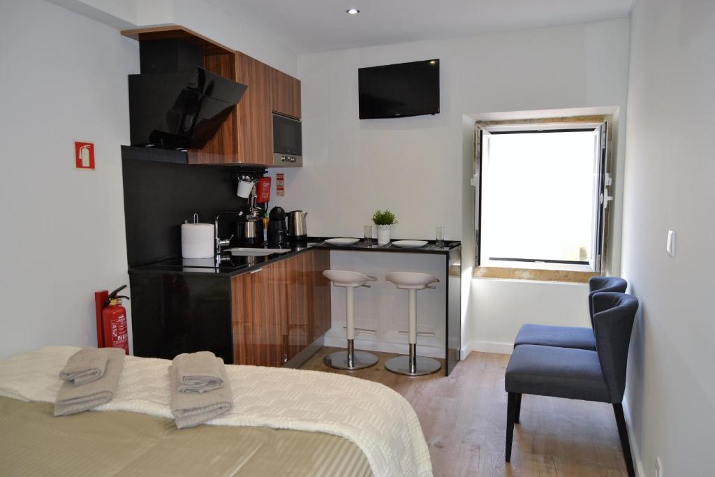 una camera da letto con un letto e una cucina con un tavolo di Modern Cozy Studio - Portas Do Sol a Lisbona