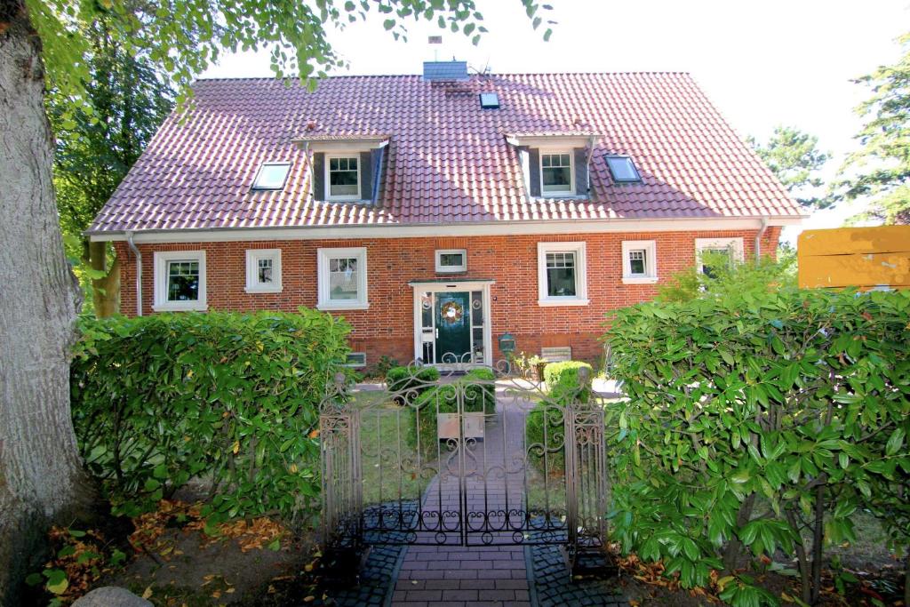 Dom z czerwonej cegły z bramą przed nim w obiekcie FeWo Ostsee Ahoi w mieście Timmendorfer Strand