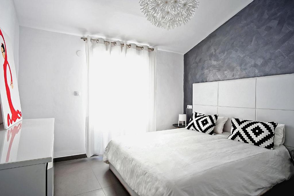 a bedroom with a white bed and a large window at Piso Centro de Castellón in Castellón de la Plana