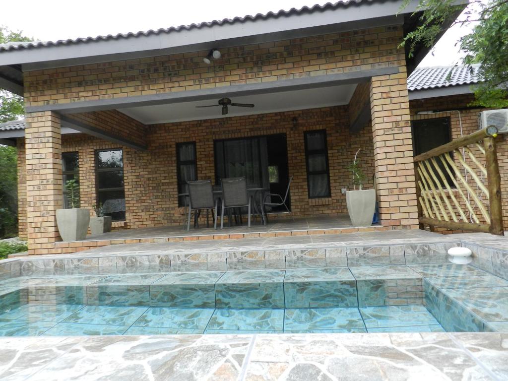 a swimming pool in front of a house at BUFFALO in Marloth Park