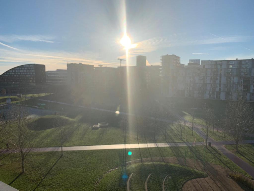 a sun shining on a city with a street light at Cute Pug Guest Room in Copenhagen