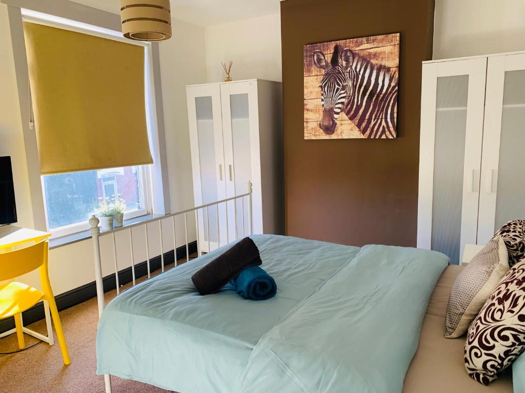 1 dormitorio con 1 cama y una foto de cebra en Durban House Kettering, en Kettering