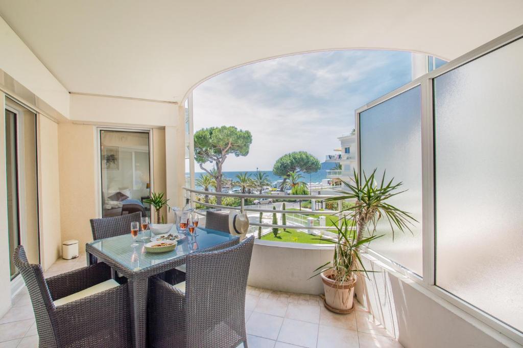 a balcony with a table and a view of the ocean at Sunlight Properties - "Kahlua" - Cannes - Sea front in Cannes