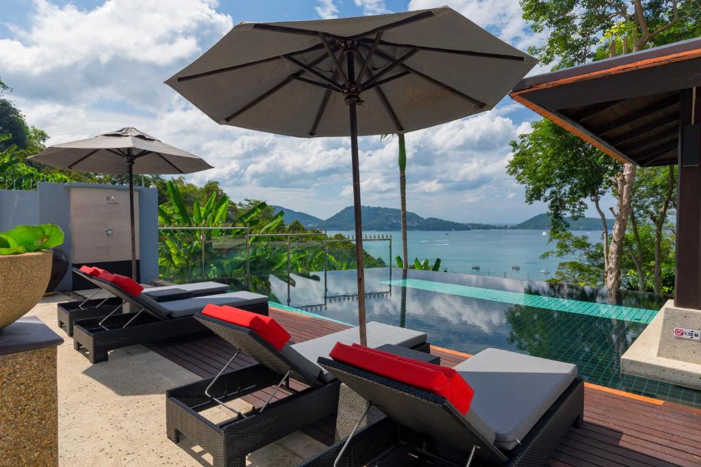 une terrasse avec des chaises et un parasol ainsi qu'une piscine dans l'établissement Villa Kalim6, à Patong Beach