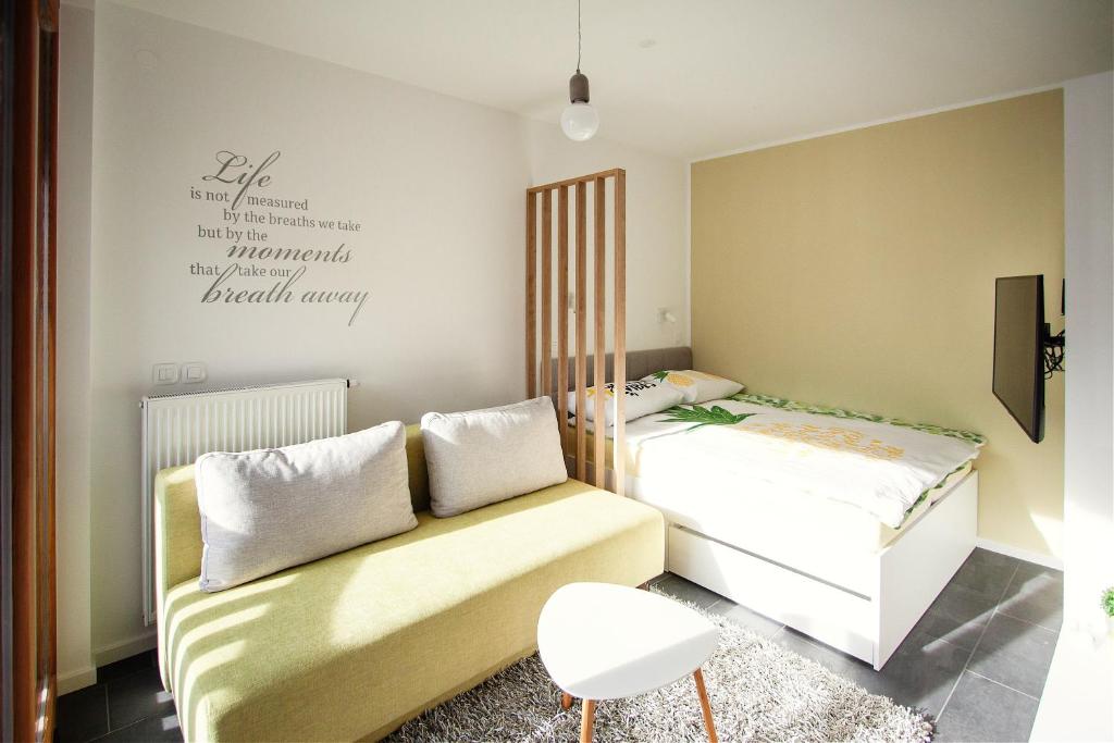 een slaapkamer met 2 bedden en een bank bij Apartment Amber, Kranjska Gora - Center in Kranjska Gora