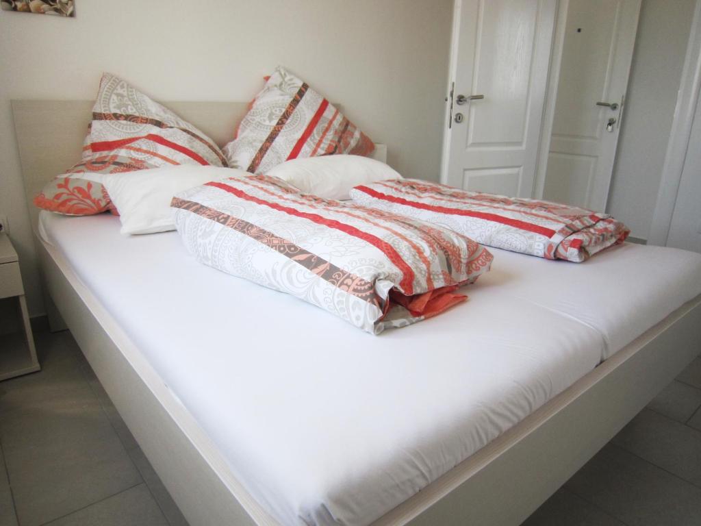 Una cama blanca con cuatro almohadas encima. en M&B guest house Srima en Srima