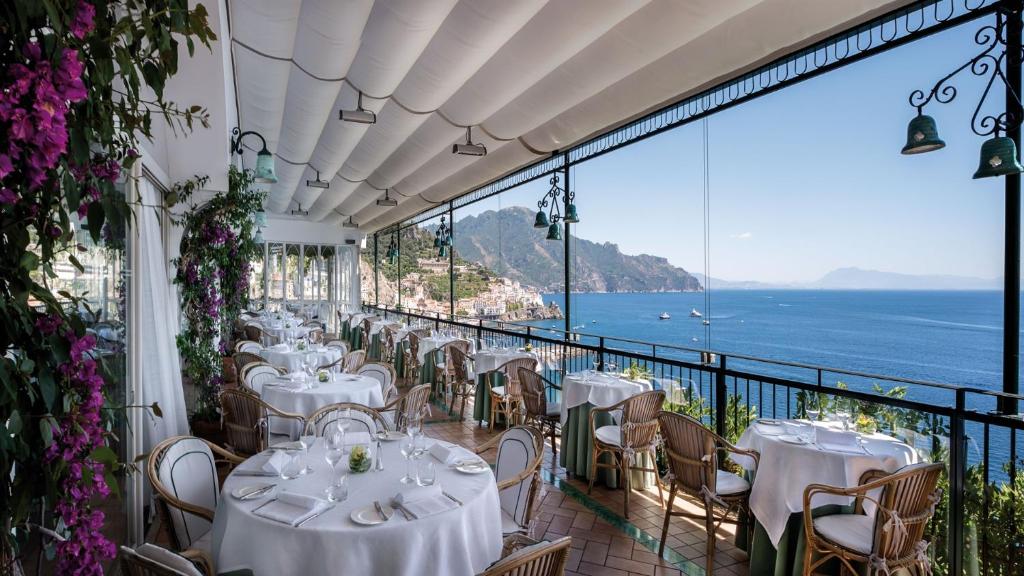 a restaurant with tables and chairs and a view of the ocean at Hotel Santa Caterina in Amalfi