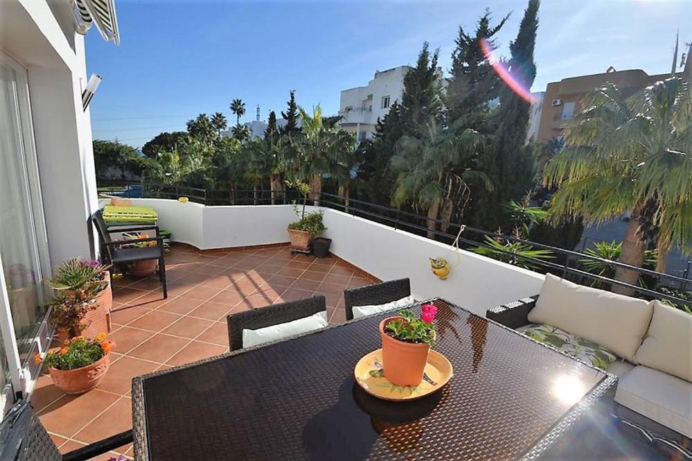 een patio met een tafel en stoelen op een balkon bij Apartamento Estepona Golf in Estepona