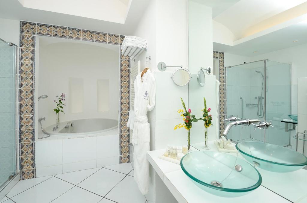 a bathroom with two sinks and a tub at Hotel Santa Caterina in Amalfi
