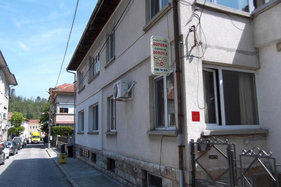 ein Schild befindet sich auf der Seite eines Gebäudes in der Unterkunft Borova House in Trjawna