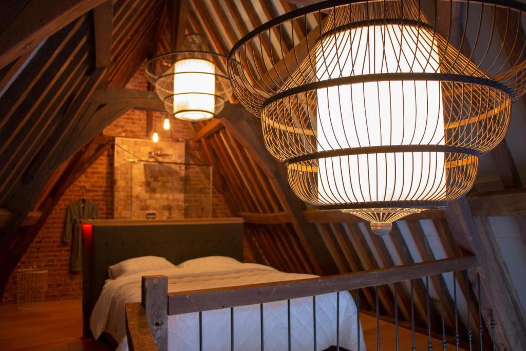 Dormitorio con cama y lámpara de araña grande en Boutique Logement Londen Centrum Middelburg en Middelburg