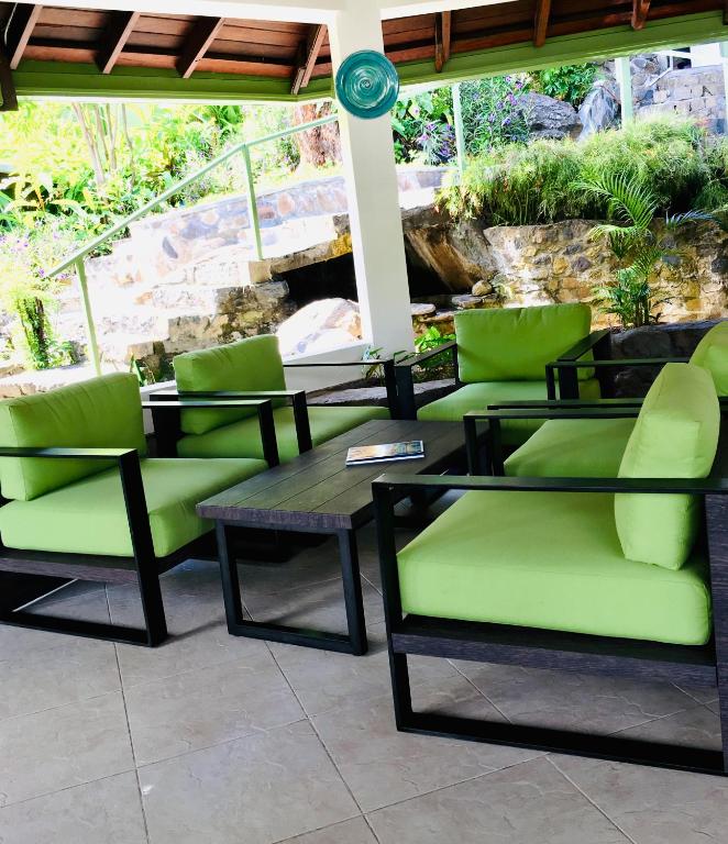 a patio with green chairs and a table at Young Island Resort in Kingstown
