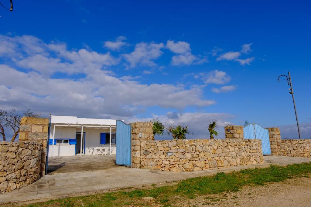 eine Steinmauer vor einem Gebäude in der Unterkunft Ville Torre del Pizzo in Gallipoli