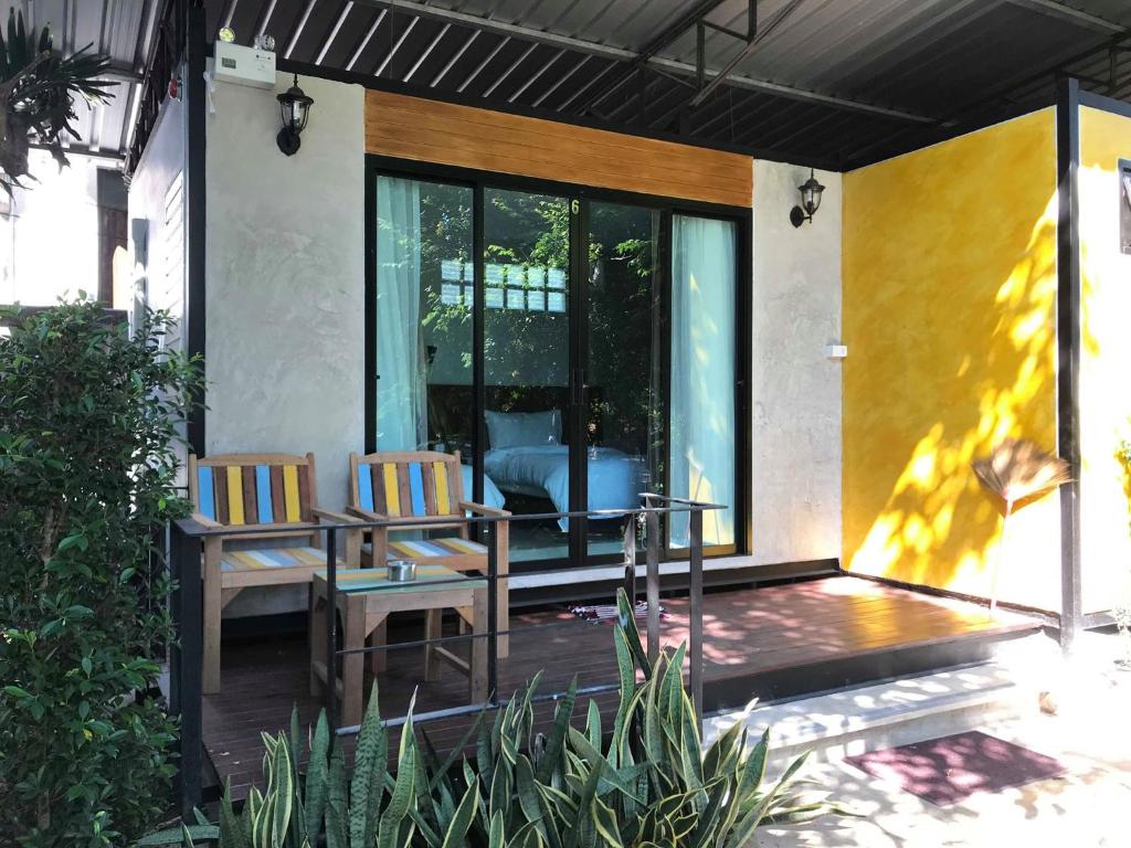 une maison avec 2 chaises et une table sur une terrasse dans l'établissement The Monkey Resort Donheang, à Prachuap Khiri Khan