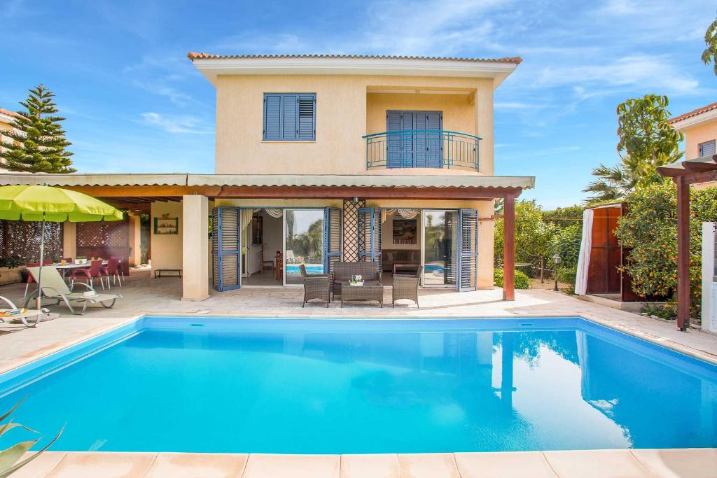 una villa con piscina frente a una casa en Latchi Marina View, en Neo Chorio