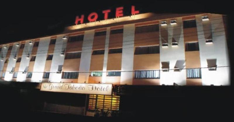 a hotel building with a hotel sign in front of it at Grand Hotel Taboao in Taboão da Serra