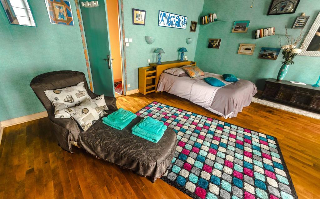 a bedroom with a bed and a chair and a rug at la maison d&#39;idylle in Combourg