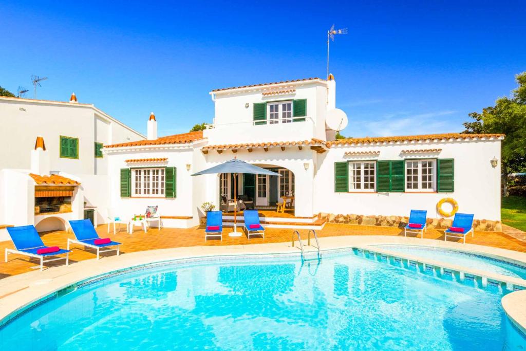 une villa avec une piscine en face d'une maison dans l'établissement Casa Maria, à Cala Galdana