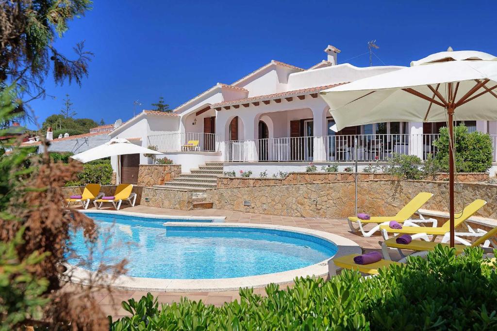 a villa with a swimming pool in front of a house at Villa Fantasia in Punta Prima