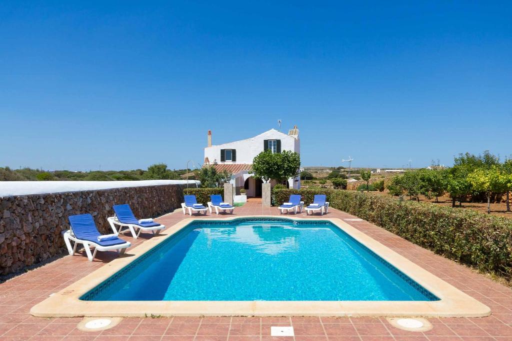 a swimming pool with chairs and a house at Villa Verde in Tres Alquerías