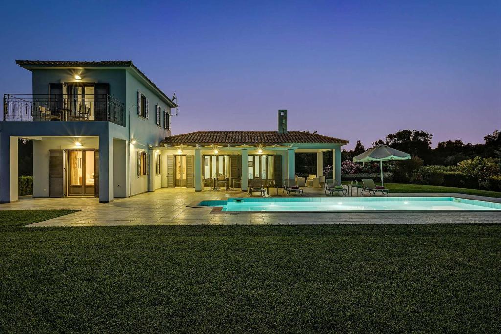 una casa grande con piscina frente a ella en Villa Votsalo en Kaligata