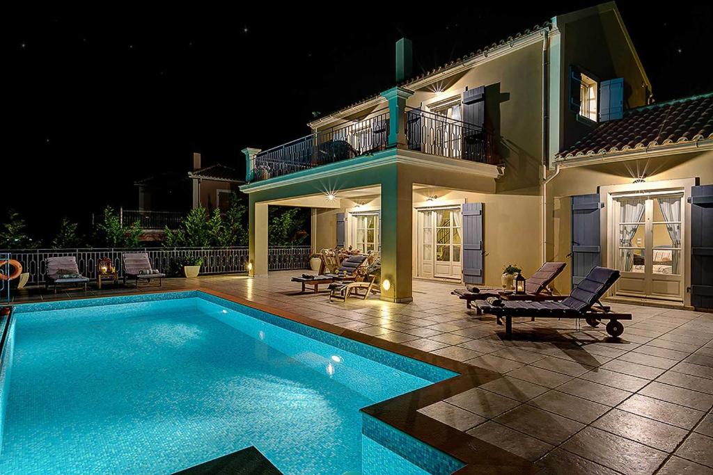 - une piscine en face d'une maison la nuit dans l'établissement Villa Persephone, à Andipáta Erísou