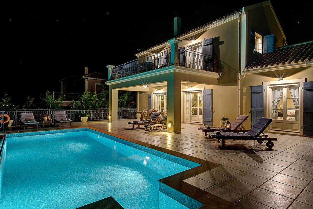 a swimming pool in front of a house at night at Villa Persephone in Andipáta Erísou