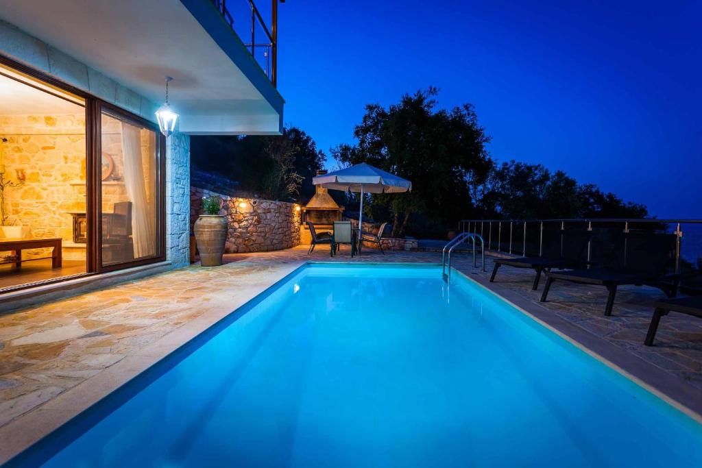 uma piscina numa casa à noite em Villa Segounia em Skinária