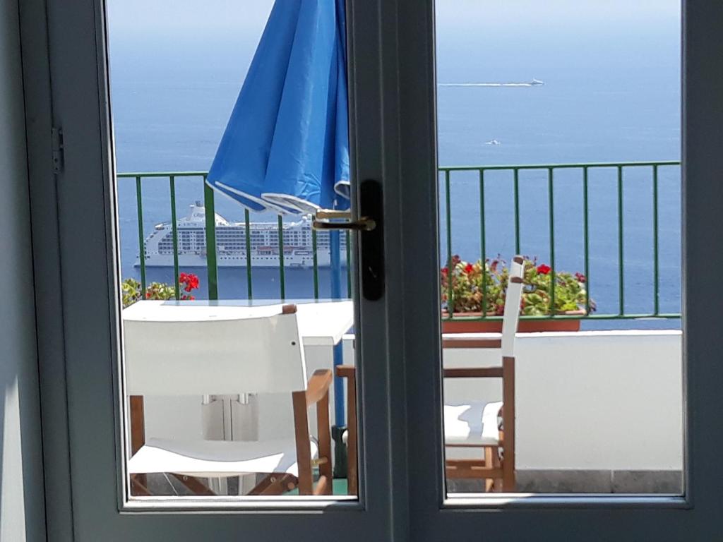 vistas a un balcón con mesa y sombrilla en Residenza Gennaro, en Amalfi