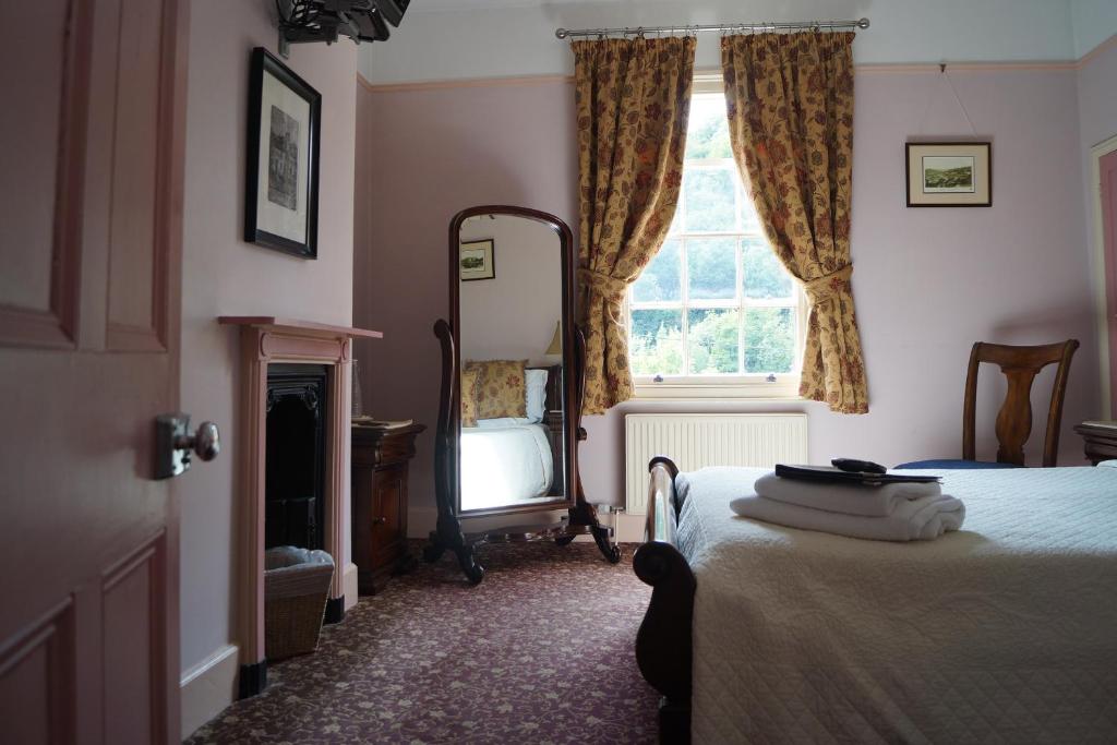 a bedroom with a bed and a mirror and a window at Foundry Masters House in Ironbridge