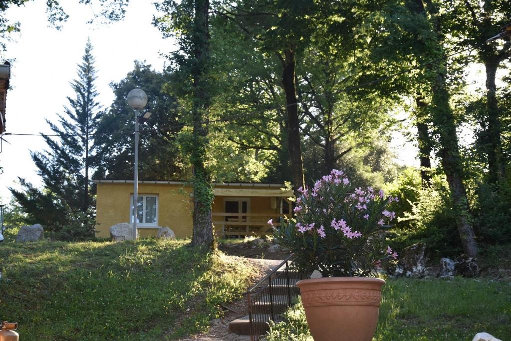 une maison avec un pot de fleurs devant elle dans l'établissement Camping La Chêneraie 4 étoiles - Gîtes, à Vers
