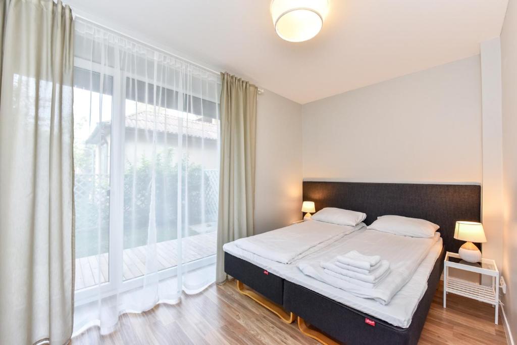 a bedroom with a bed and a large window at Liepų apartamentai in Palanga