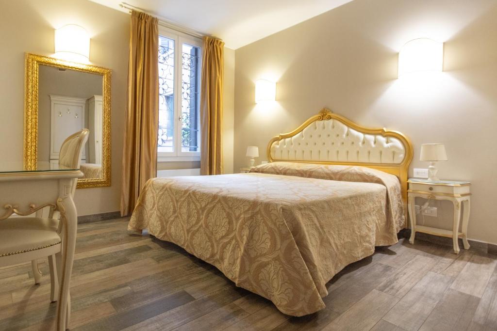 a bedroom with a bed and a mirror and a chair at Doge's House in Venice