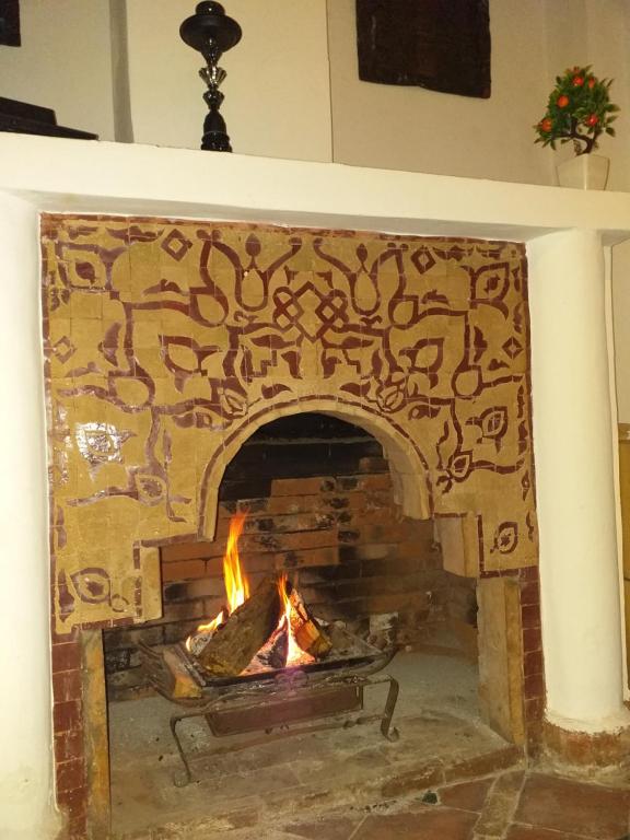 a brick fireplace with a fire in it at Riad Assalam in Marrakech