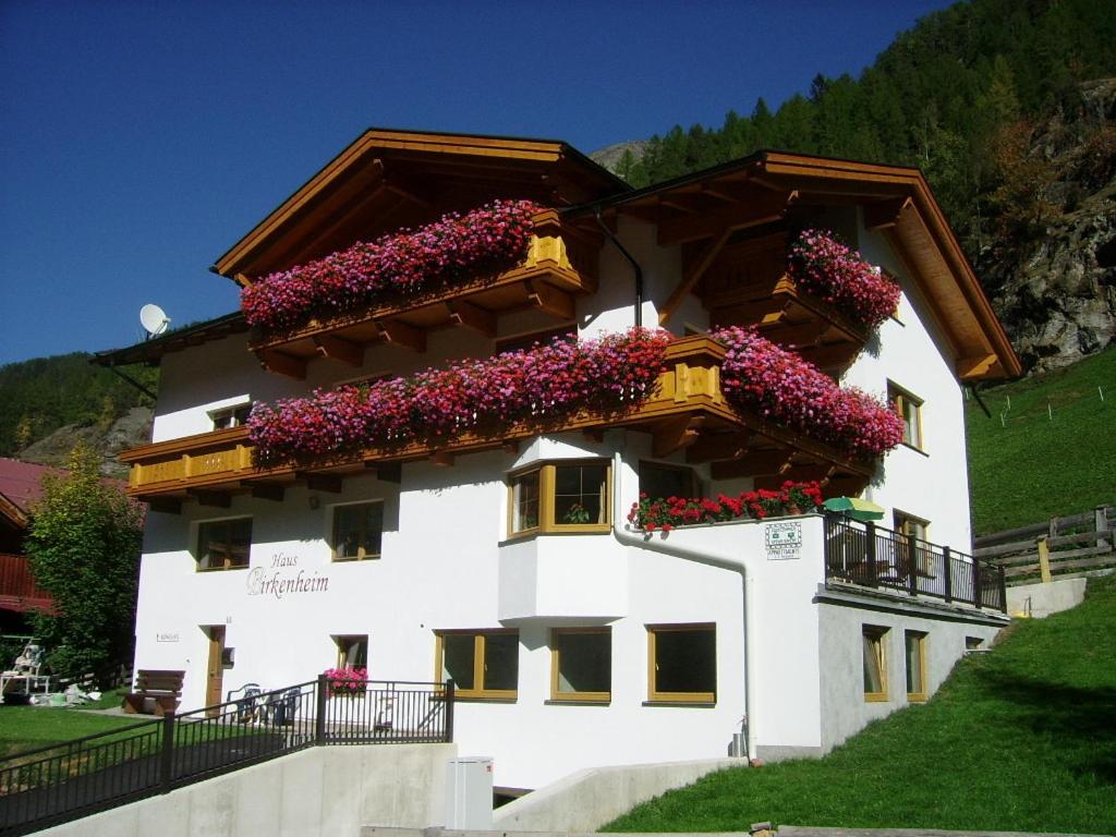 ein Gebäude mit Blumen auf der Seite in der Unterkunft Haus Birkenheim in Sölden