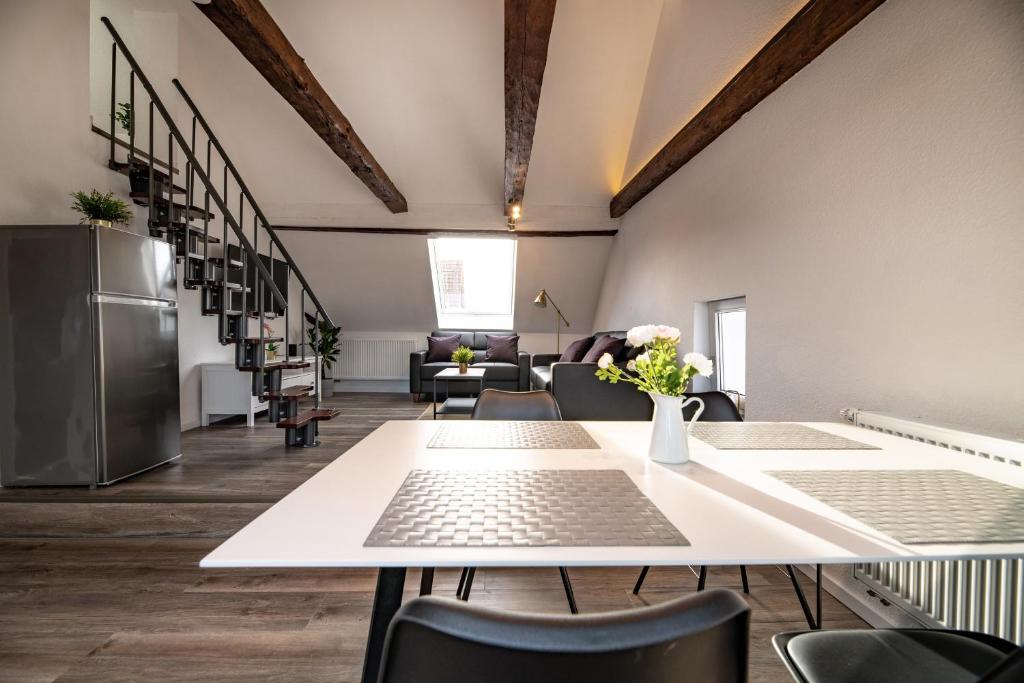 una camera con tavolo e sedie e una cucina di Ganze Wohnung in Bad Buchau am Federsee a Bad Buchau