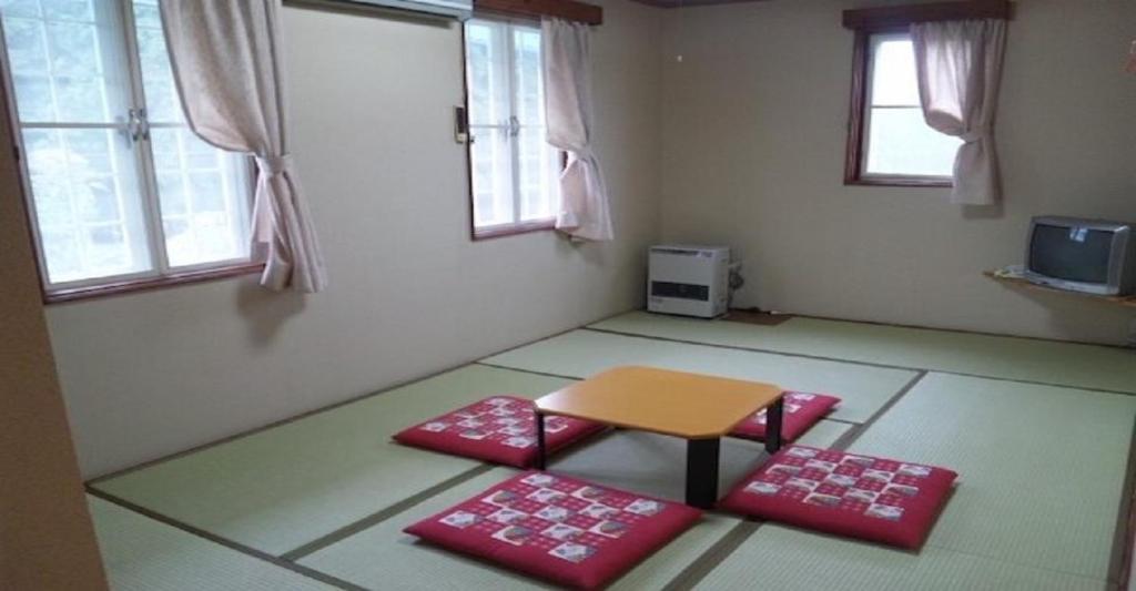 南魚沼市にあるPension Come Tatami-room with a calm atmosphere - Vacation STAY 14983のテーブルと赤いマット2枚が備わる部屋
