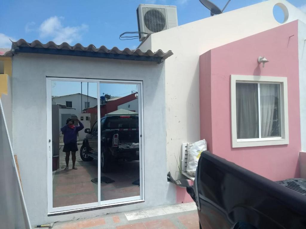 une personne debout devant une porte d'une maison dans l'établissement Villa marina, santa elena, à Santa Elena