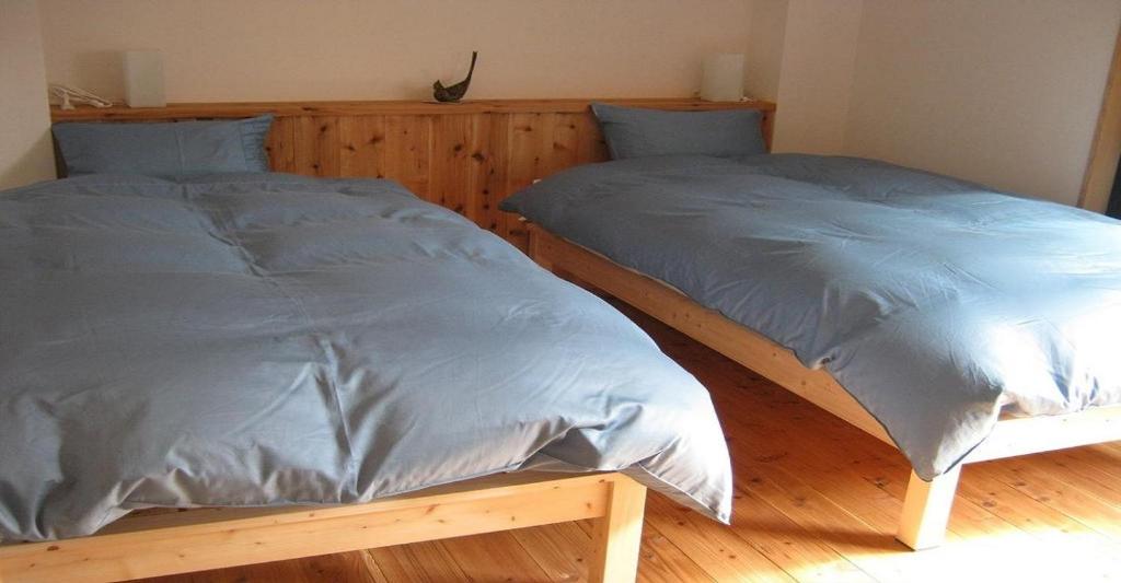 two beds sitting next to each other in a bedroom at Guesthouse Hyakumanben Cross twin room / Vacation STAY 15395 in Kyoto