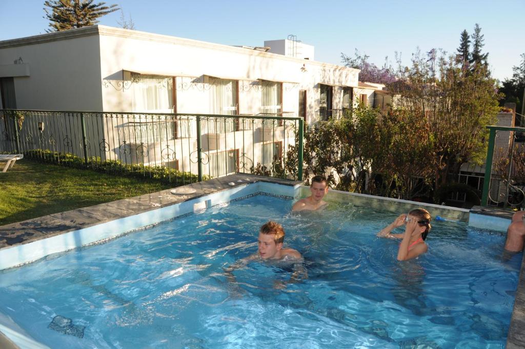 a group of people swimming in a swimming pool at Hotel Boutique Villa Elisa in Arequipa